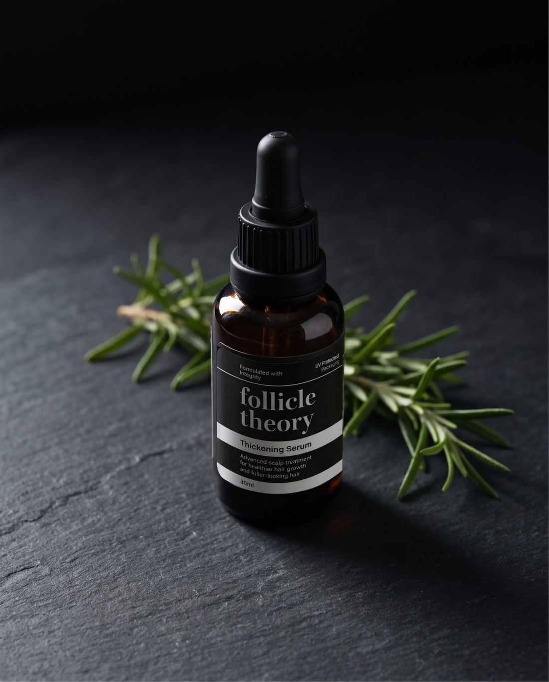 follicle theory Thickening Serum on slate with fresh rosemary